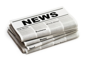 a folded up newspaper with "NEWS" written on the top.  The newspaper has 4 visible sections all stacked on top of each other, on a white background.