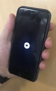 hand holding phone with Uber app